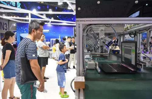 ▲8月23日，观众在首届中国国际智能产业博览会上参观笔记本电脑智能测试线。